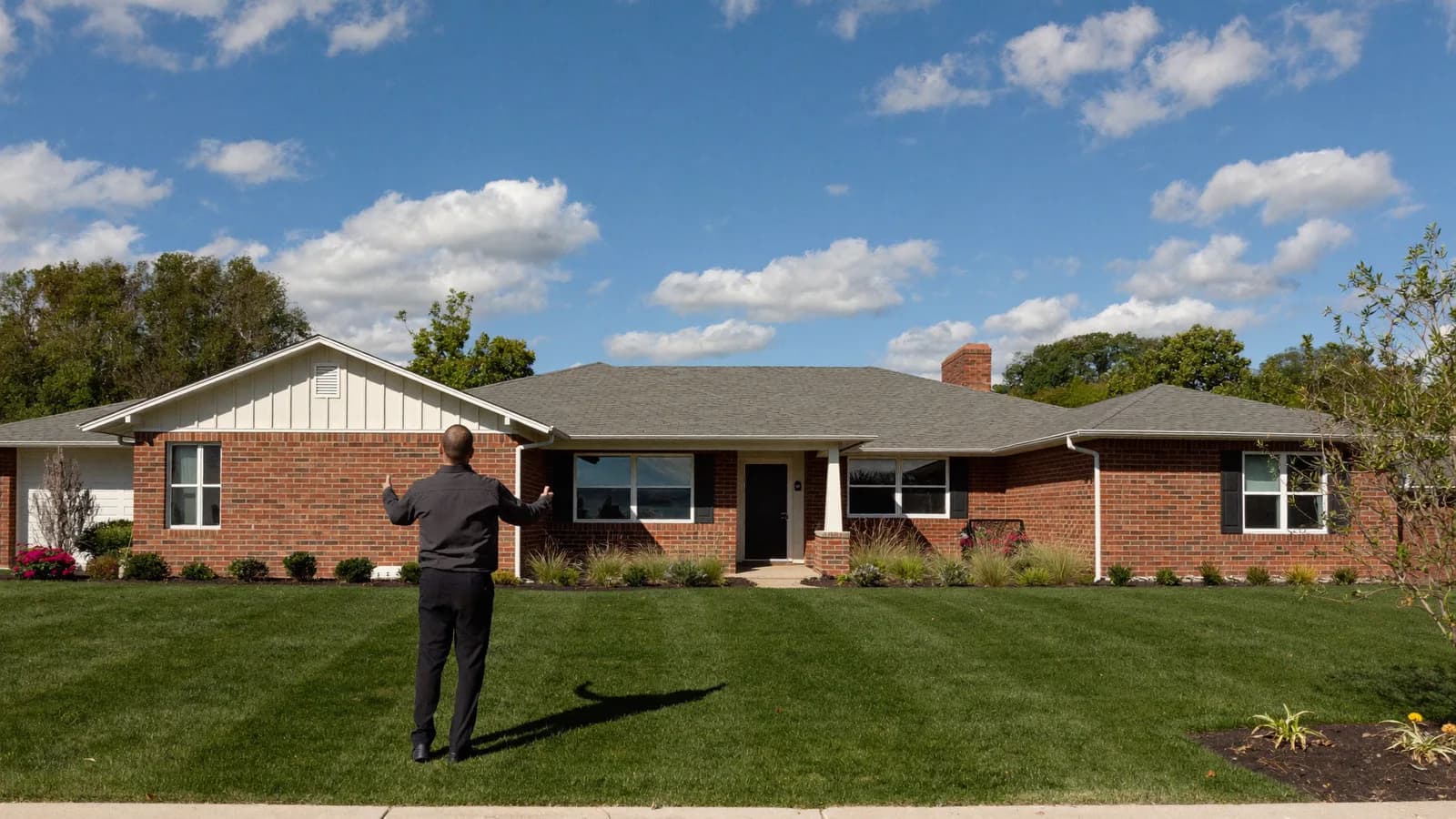 Dallas landlord walking a property manager through a single-family brick rental home in a North Texas neighborhood