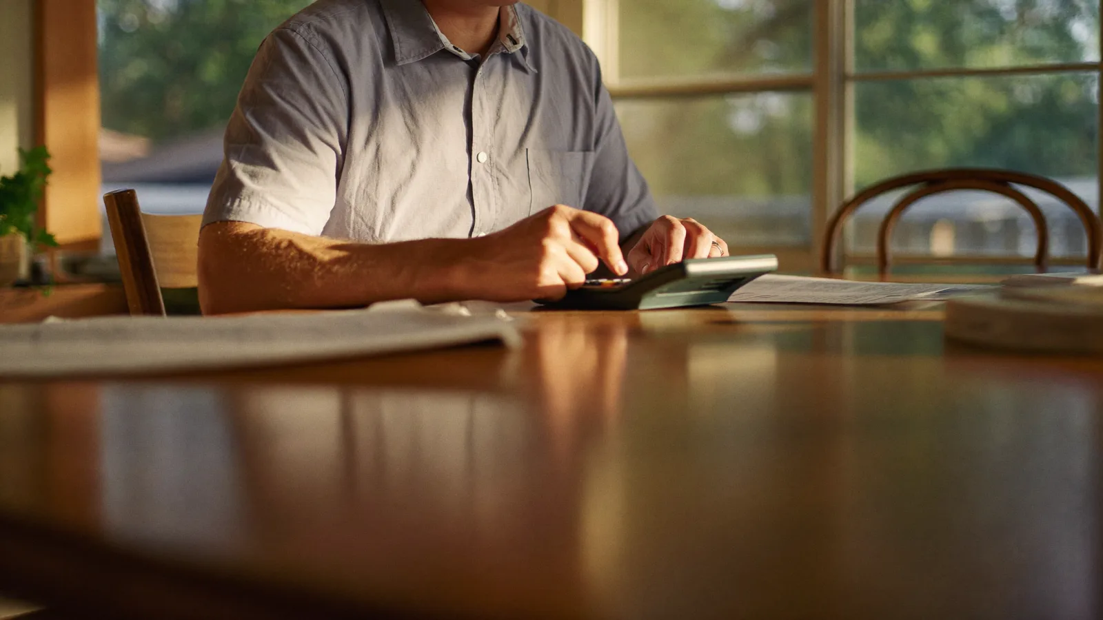 Fort Worth landlord reviewing rental income spreadsheets and fee statements at a home office desk