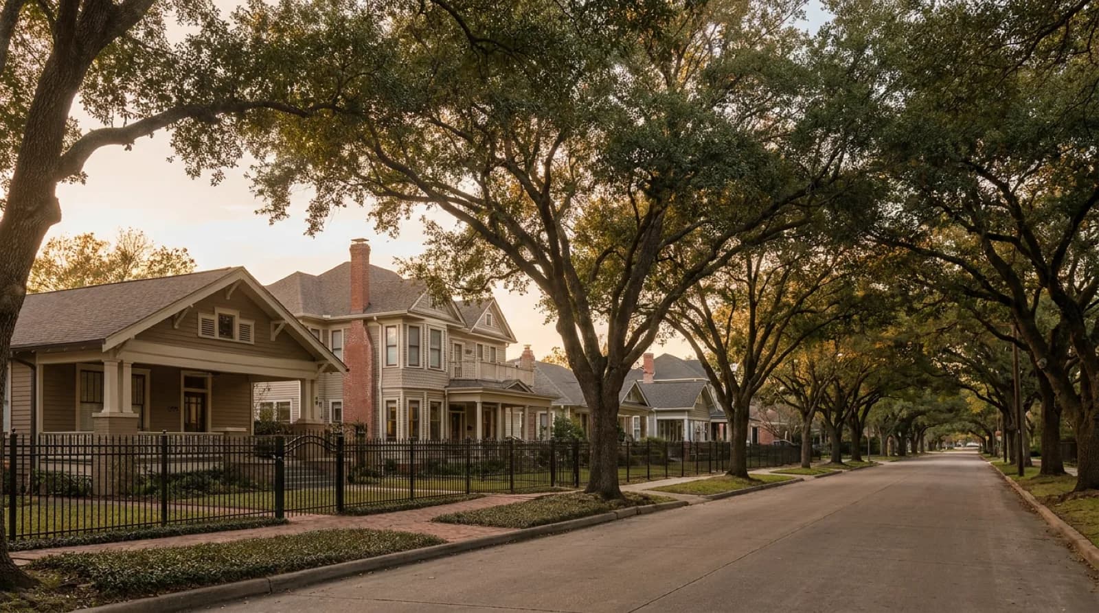 Tree-canopied historic Houston Heights residential streetscape with restored 1920s craftsman bungalows and Queen Anne Victorian homes in golden afternoon light — the protected single-family rental stock inside the Houston Heights Historic District overlay