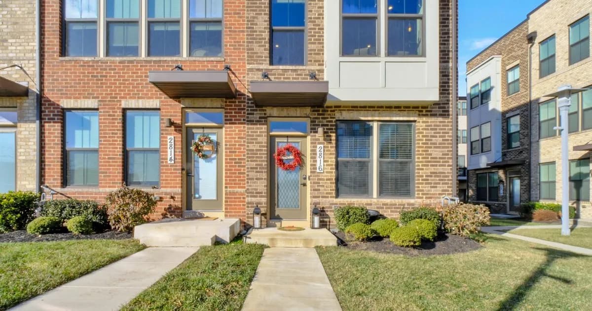 Stately brick single-family estate homes on a wooded Potomac street in warm daylight — the Montgomery County MCPS Winston Churchill-cluster stock that anchors Great Falls and Congressional-area rental demand