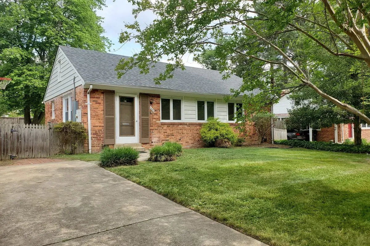 Brick rambler single-family rental home on a tree-lined street in a Northern Virginia suburb with a manicured lawn