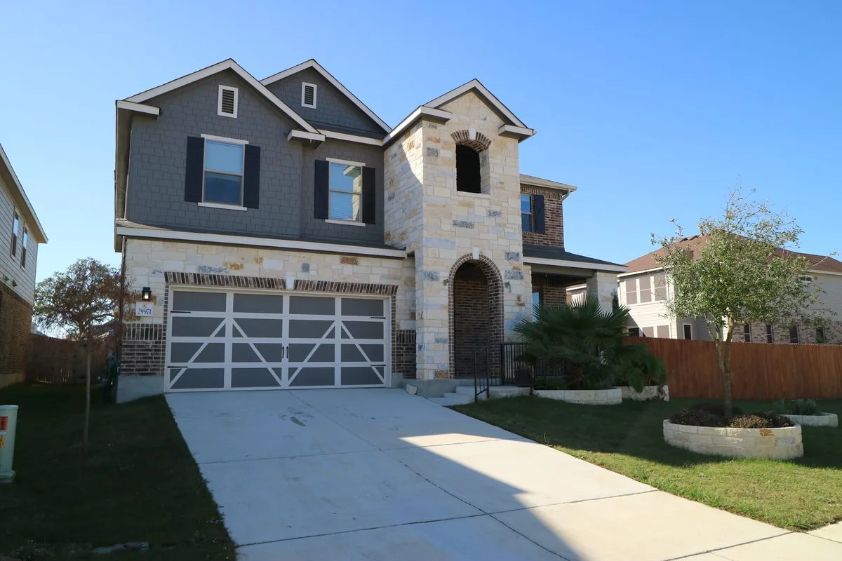Brick two-story single-family rental home in a San Antonio-area suburb with a manicured lawn and attached garage
