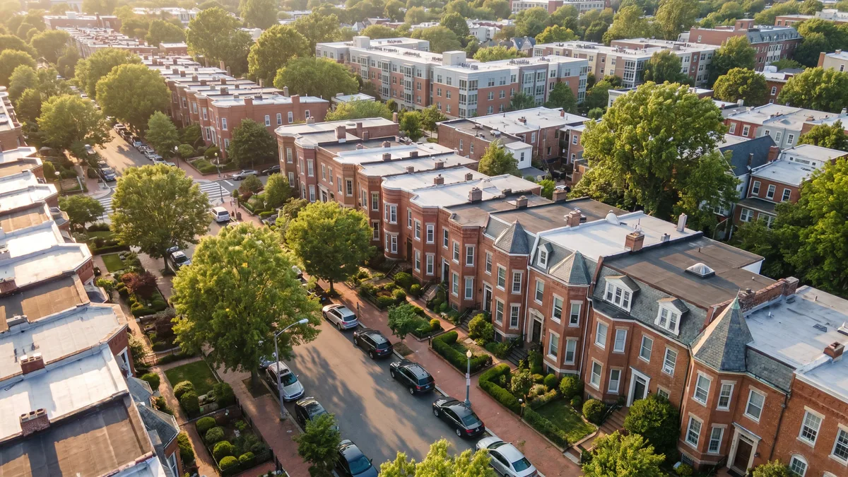 Aerial view of an established close-in Washington DC neighborhood with blocks of brick rowhouses, mature street trees, and low condo buildings at golden hour